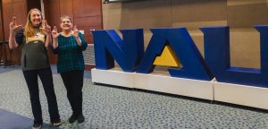 Lucy Sullivan and Colleen Rice in front of the NAU sign