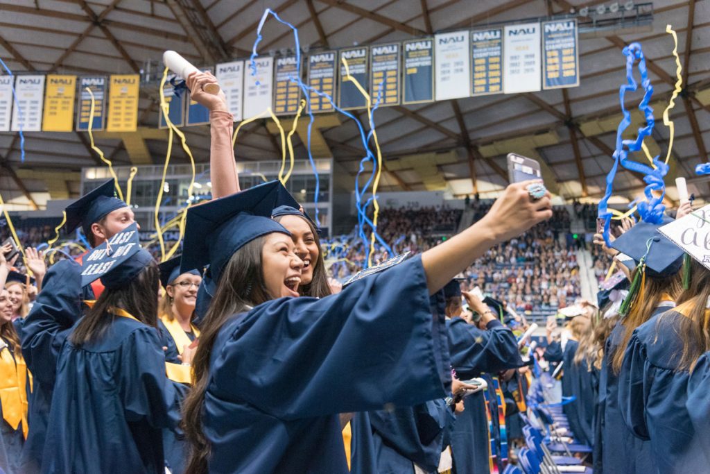 Two students take a selfie at NAU commencement