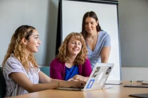 Dawn Clifford looking over a student's shoulder as the student points to something on a laptop