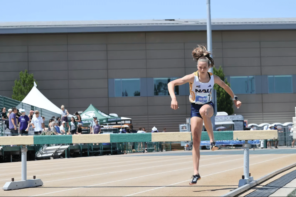 Sophomore Karrie Baloga competes in the 3,000-meter steeplechase, jumping over an obstacle.