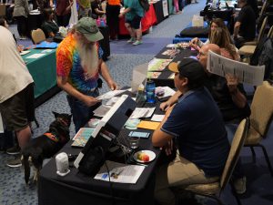 Man with dog getting information from a vendor at the Disability Resource Fair in Flagstaff 2024.