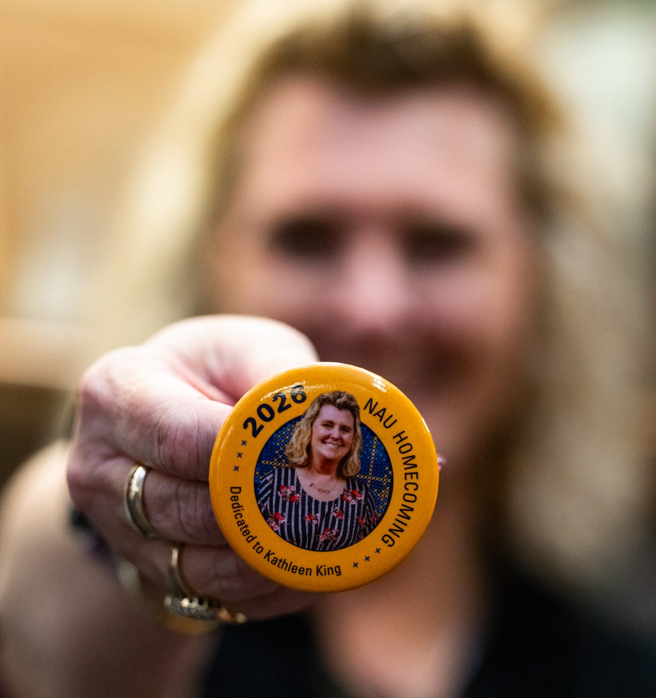 Kathleen King holds up a button with her face on it