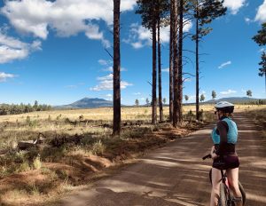 Cyclist standing on top of the bike on a trail.
