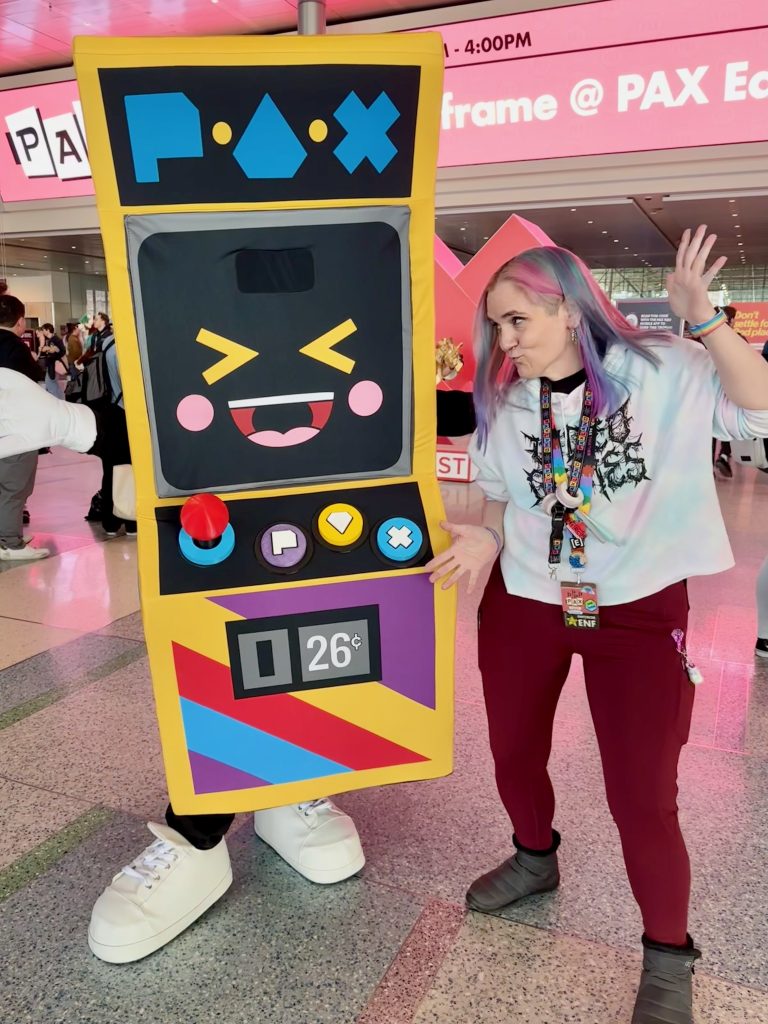 Stephanne dancing next to a person dressed up as a Pac-Man machine.