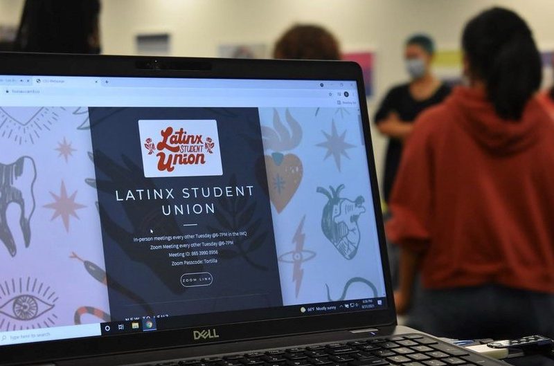 Image of laptop with LSU webpage and students in background