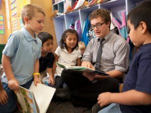 Teacher working with young students.